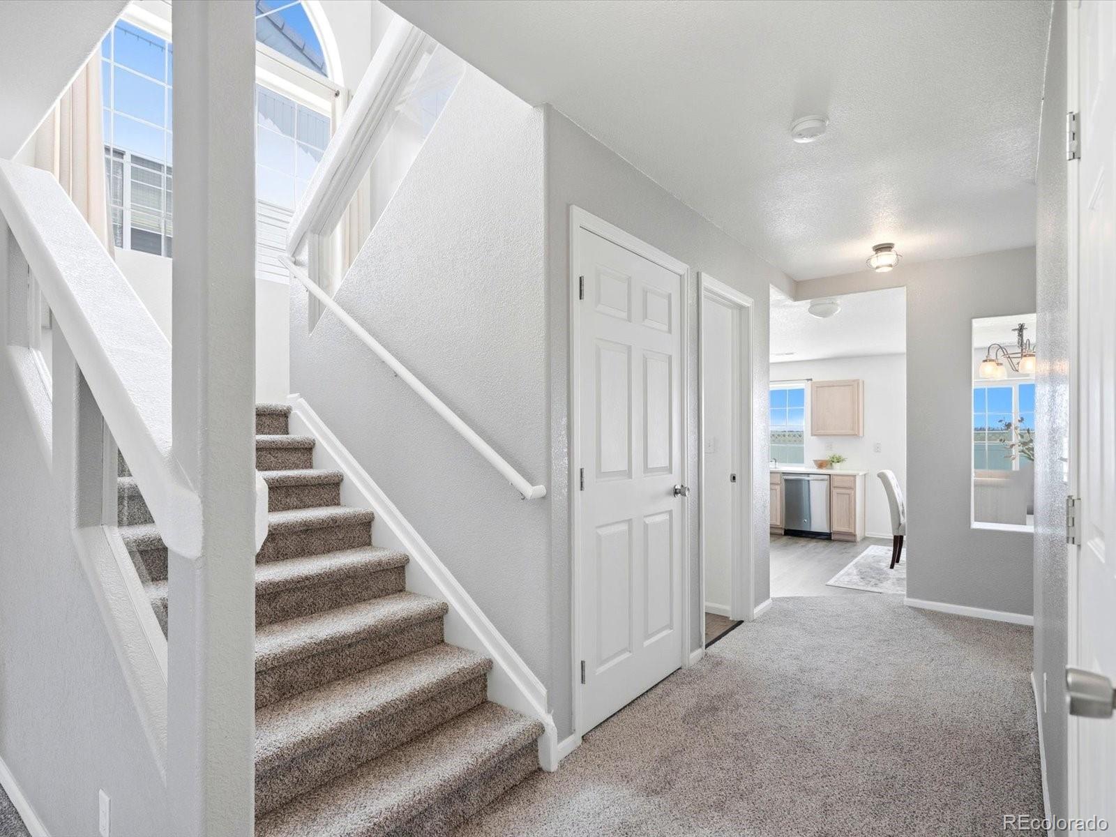 5444 Perth Court Denver, CO 80249 - Photo 7 of 46 a view of a hallway with staircase and white walls