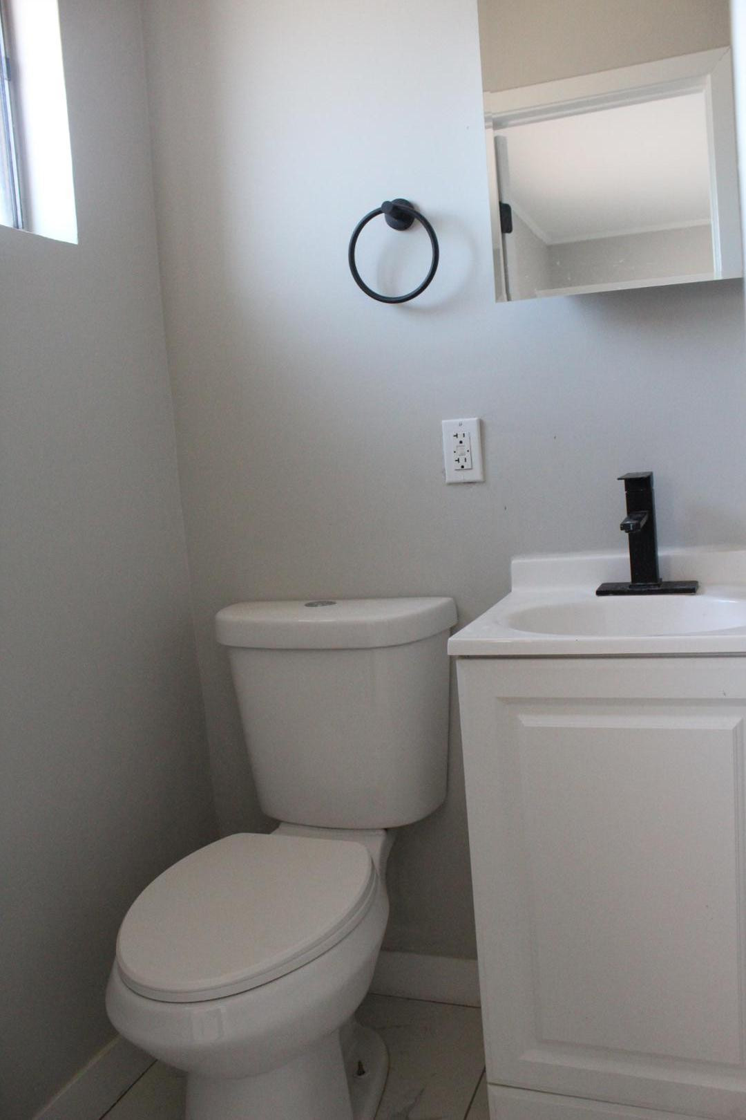 3932 West Griswold Road Phoenix, AZ 85051 - Photo 15 of 20 a white toilet sitting next to a sink and vanity