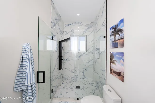 a bedroom with a bed and a large window with the outer view