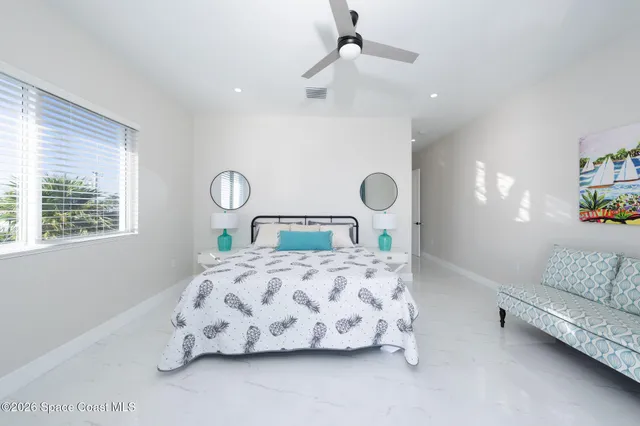 a bedroom with a bed a chandelier and a window