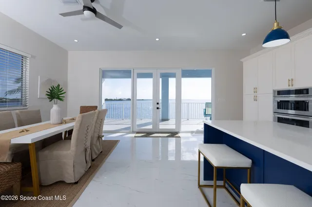 a living room with furniture kitchen view and a chandelier