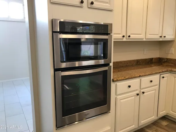 a kitchen with granite countertop white cabinets and stainless steel appliances