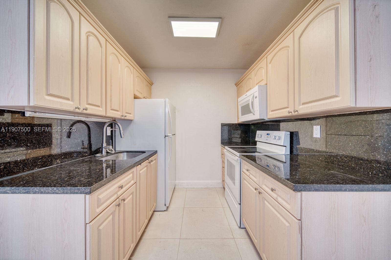 400 Minorca Avenue, Unit 1 Coral Gables, FL 33134 - Photo 5 of 21 a kitchen with granite countertop a sink stainless steel appliances and cabinets