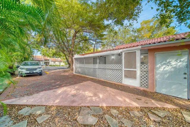 a view of a house with a large tree and a yard