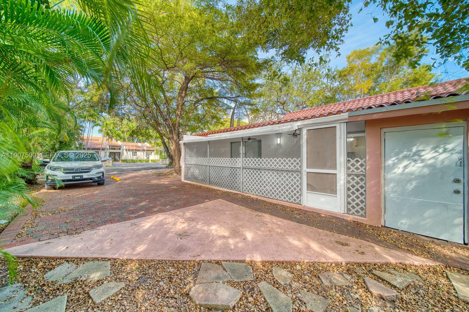 400 Minorca Avenue, Unit 1 Coral Gables, FL 33134 - Photo 8 of 21 a view of a house with a large tree and a yard