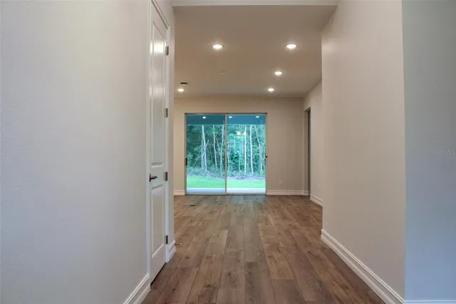 a view of hallway with a large window and wooden floor