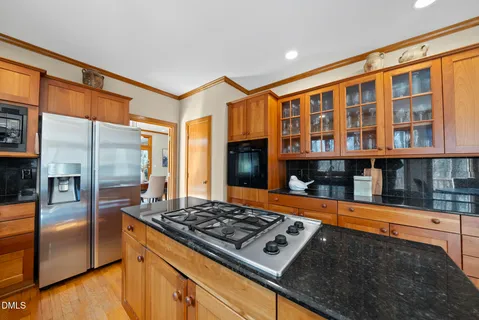 a kitchen with stainless steel appliances granite countertop a stove a sink dishwasher and cabinets with wooden floor