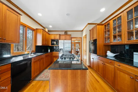a kitchen with granite countertop a sink a counter and cabinets