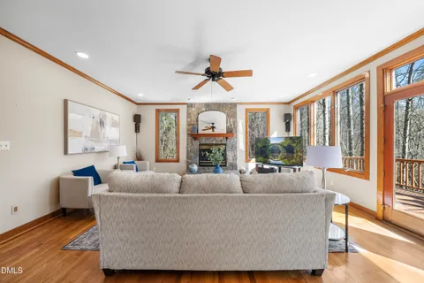 a living room with furniture a large window and a chandelier