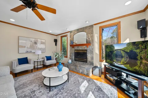 a living room with furniture a flat screen tv and a large window