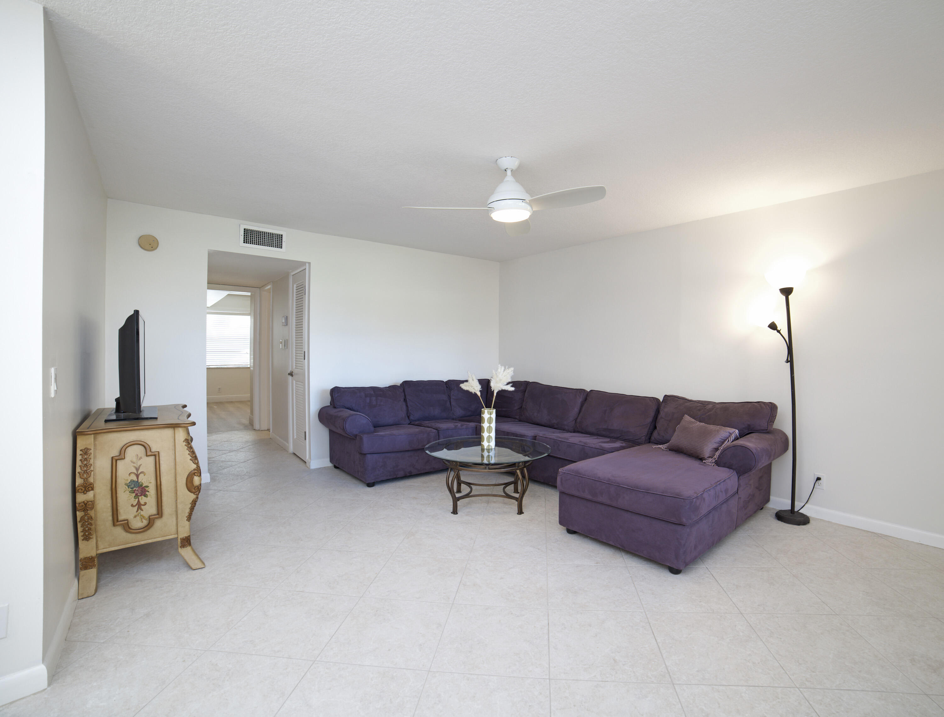 247 Capri F Delray Beach, FL 33484 - Photo 6 of 30 a living room with furniture a lamp and a window