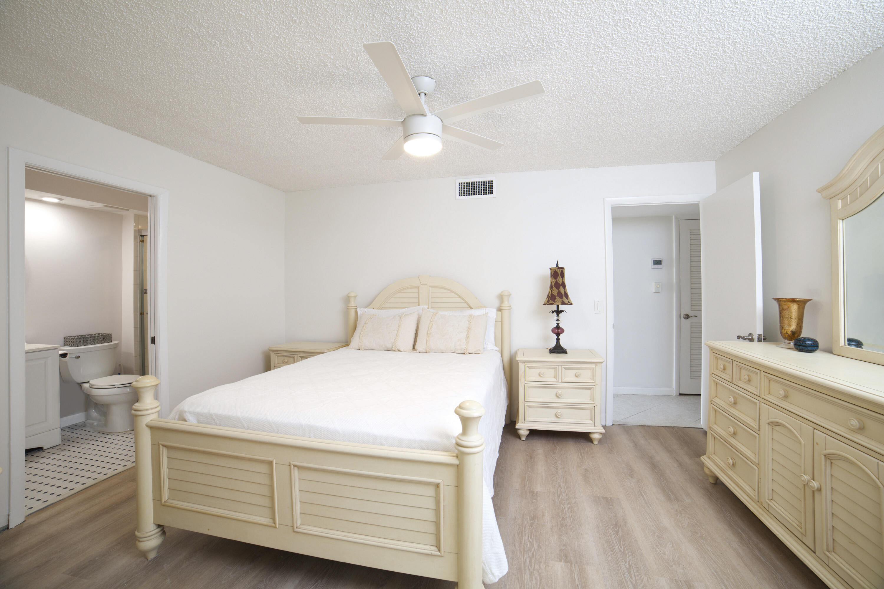 247 Capri F Delray Beach, FL 33484 - Photo 7 of 30 a bedroom with a bed and a chandelier