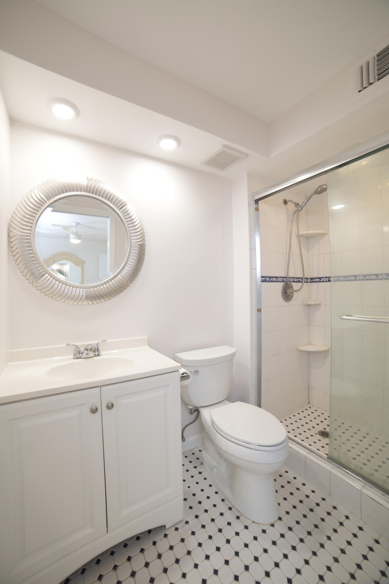 247 Capri F Delray Beach, FL 33484 - Photo 9 of 30 a bathroom with a sink a toilet and a mirror