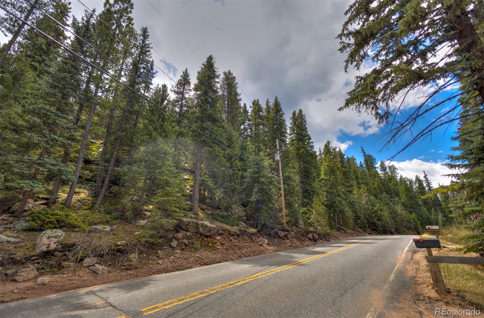 8116 South Brook Forest Road Evergreen, CO 80439 - Photo 15 of 18 a view of a road with a trees
