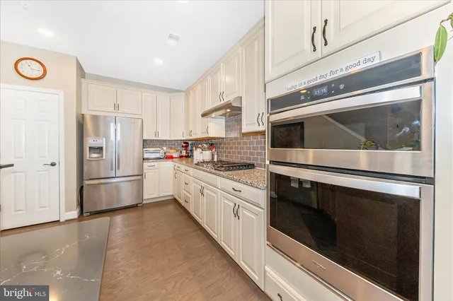 a dining room with furniture a chandelier and wooden floor
