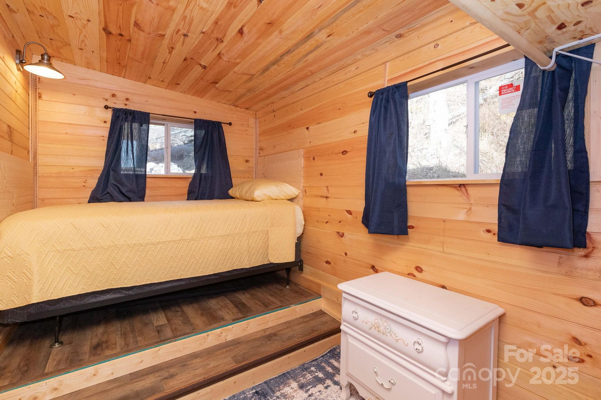 1010 Melton Branch Road Bakersville, NC 28705 - Photo 13 of 43 a bedroom with a bed a dresser next to a window