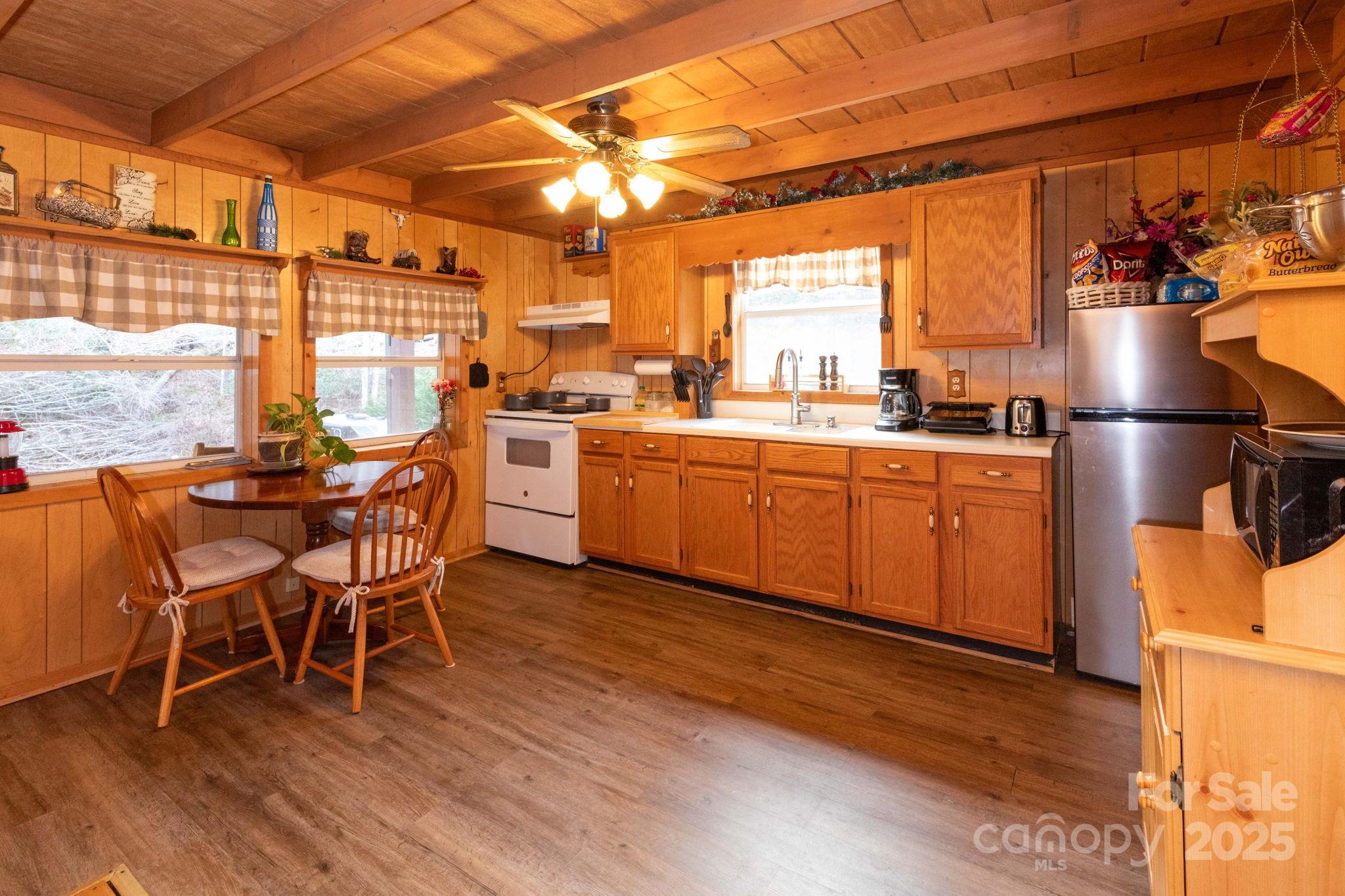 1010 Melton Branch Road Bakersville, NC 28705 - Photo 25 of 43 a kitchen with stainless steel appliances a dining table chairs and wooden floor