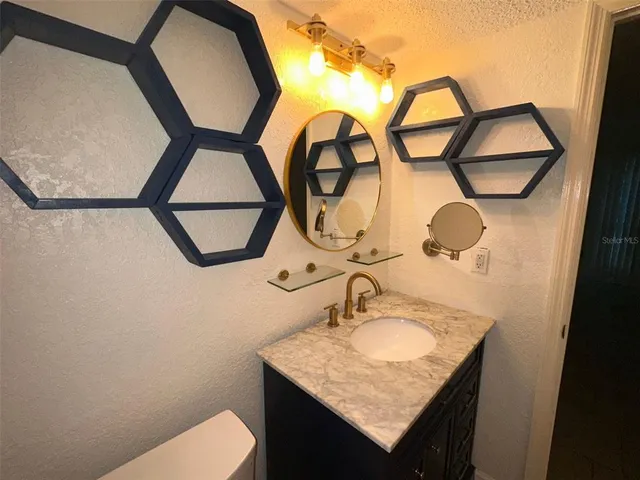 a view of a brick house with plants and large tree