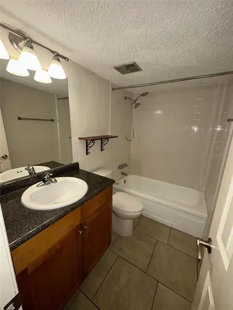 a bathroom with a granite countertop sink toilet and a mirror