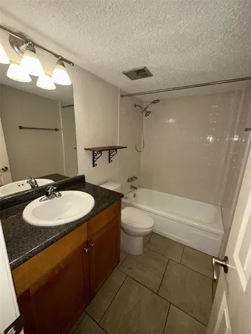 a bathroom with a granite countertop sink toilet and a mirror