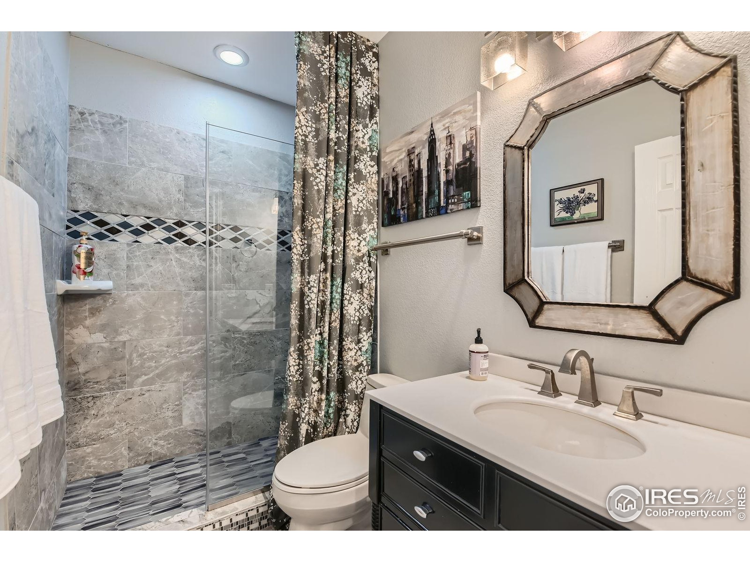 10834 Graphite Street Broomfield, CO 80021 - Photo 22 of 34 a bathroom with a granite countertop sink mirror toilet and shower