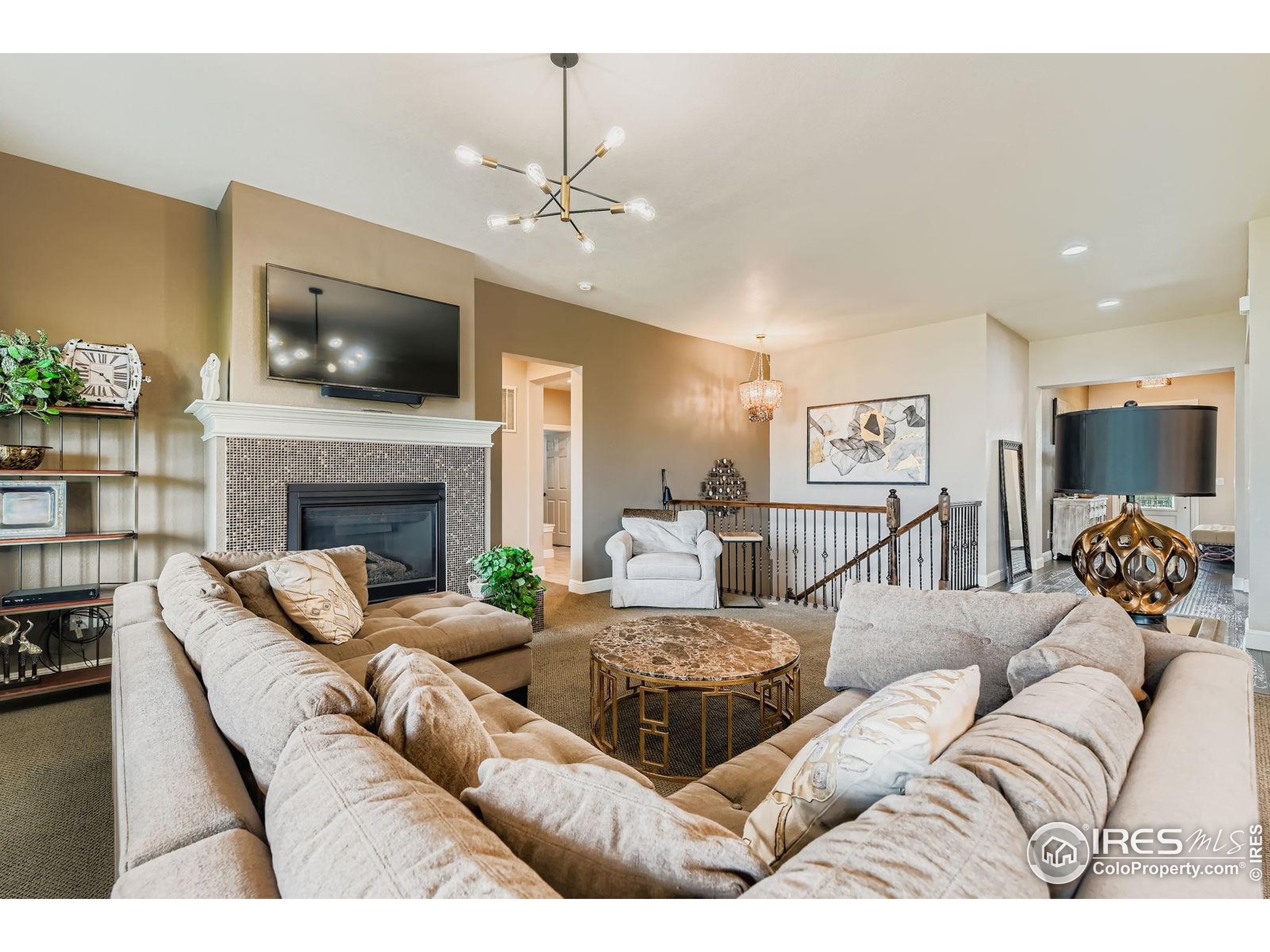 10834 Graphite Street Broomfield, CO 80021 - Photo 4 of 34 a living room with furniture a flat screen tv and a fireplace