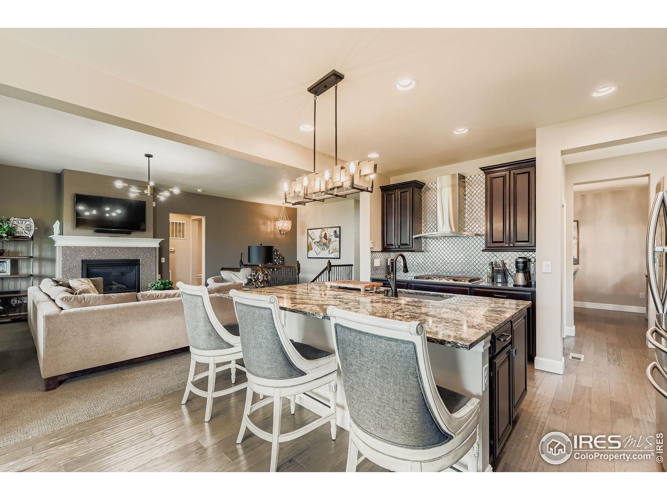 10834 Graphite Street Broomfield, CO 80021 - Photo 6 of 34 a kitchen with stainless steel appliances kitchen island granite countertop a sink and a refrigerator