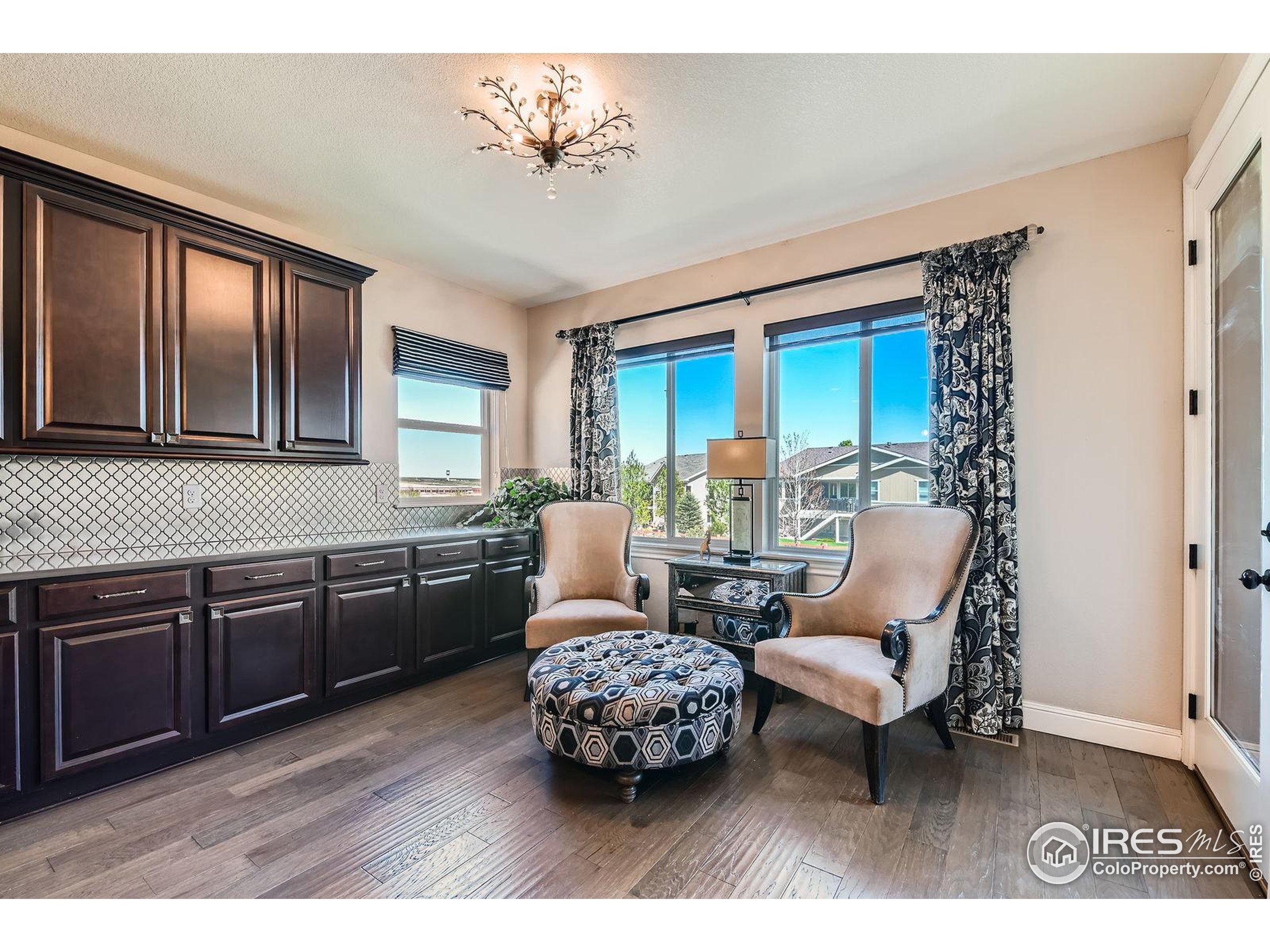 10834 Graphite Street Broomfield, CO 80021 - Photo 8 of 34 a living room with furniture two large window and wooden floor