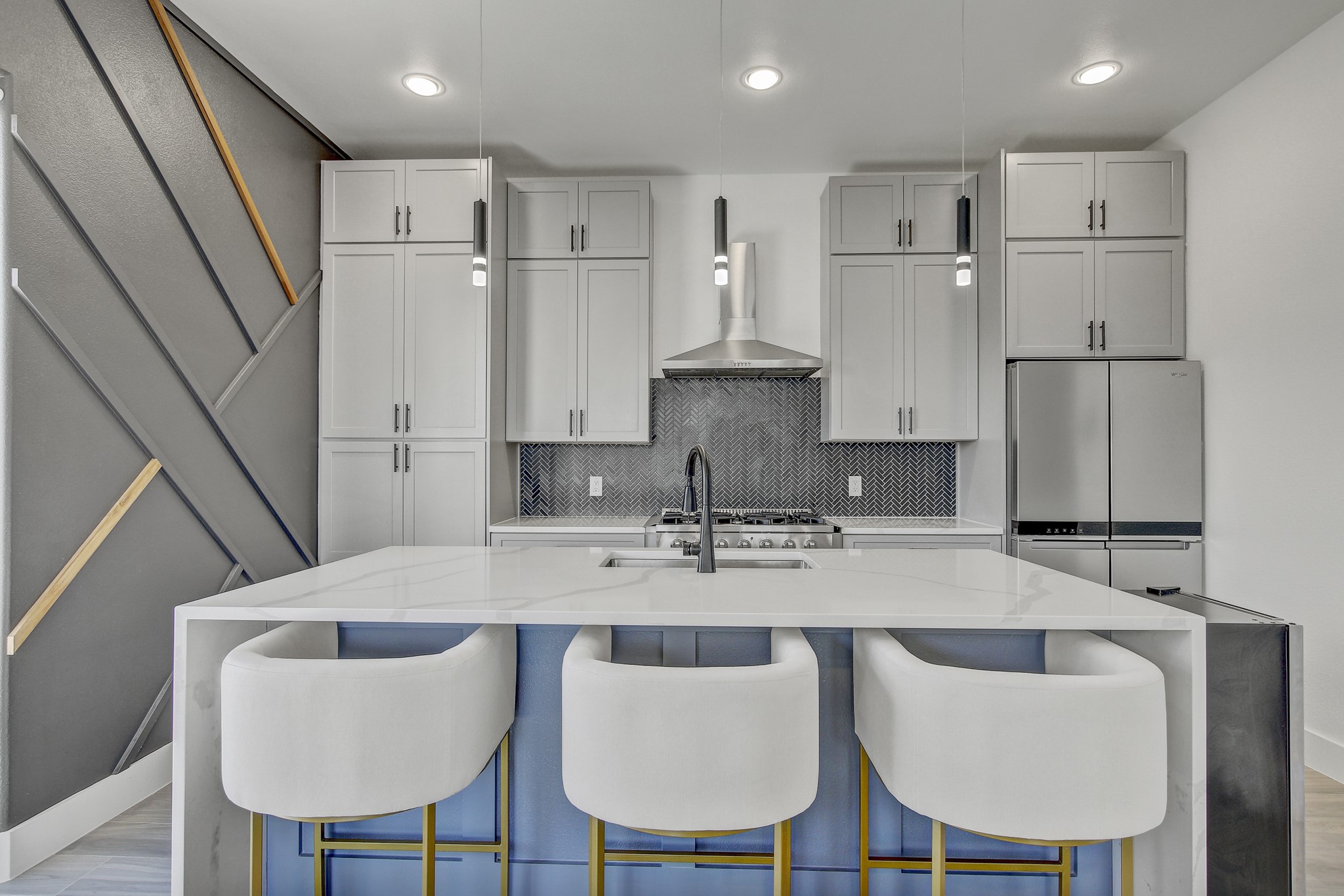4703 Louis Avenue, Unit A Austin, TX 78721 - Photo 10 of 35 Kitchen featuring light stone countertops, freestanding refrigerator, a center island with sink, a breakfast bar, and recessed lighting