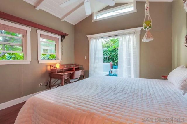 a bedroom with a bed table chair and a window