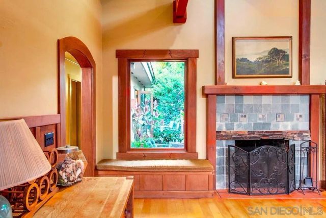 a living room with a fireplace and a large window