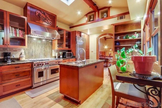 a kitchen with stainless steel appliances granite countertop a stove a sink and a refrigerator
