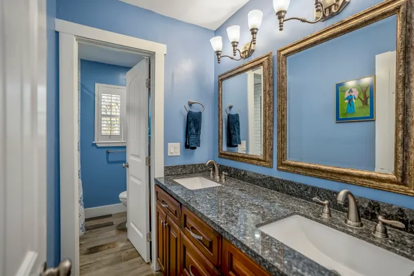 a bathroom with a granite countertop sink and a mirror