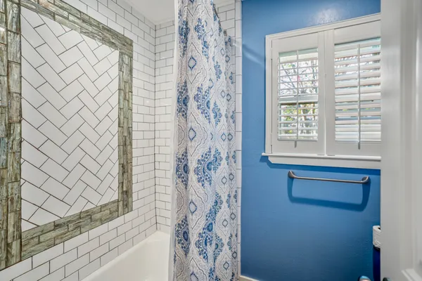 a bathroom with a shower curtain and a window