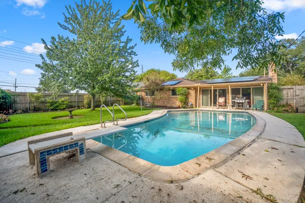a view of a house with a swimming pool and sitting area