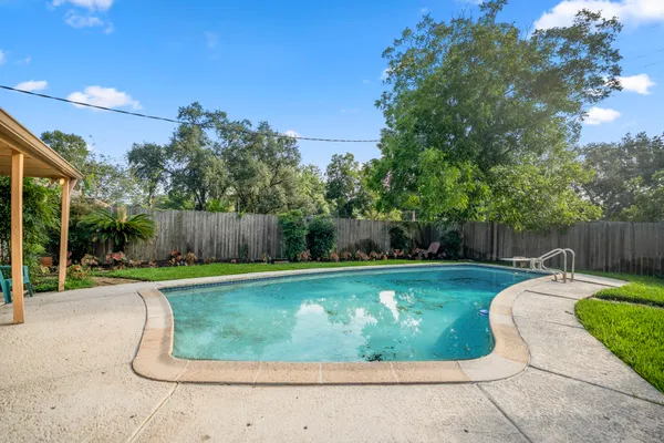 a view of a backyard with swimming pool