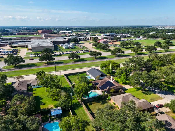 an aerial view of residential houses with outdoor space and lake view
