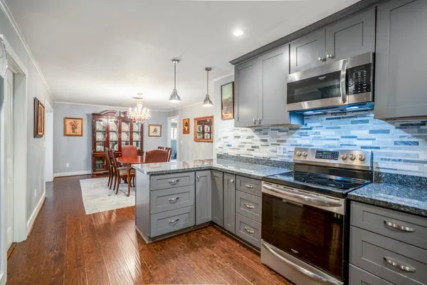 a kitchen with stainless steel appliances granite countertop wooden cabinets and a stove top oven