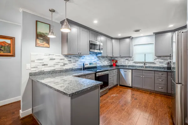 a kitchen with stainless steel appliances granite countertop a sink stove and refrigerator