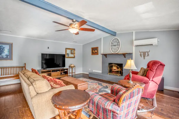 a living room with furniture a flat screen tv and a fireplace