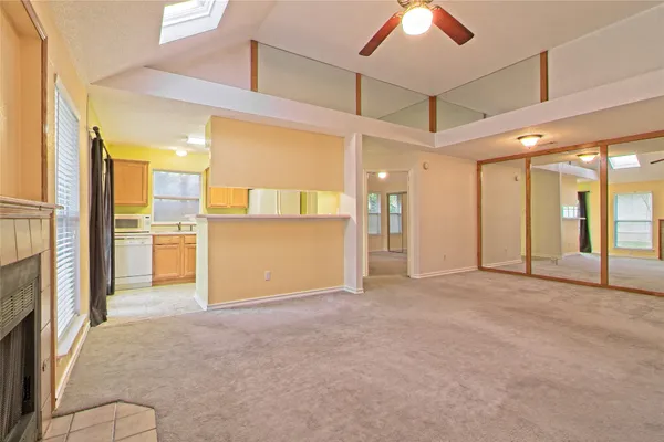 a view of empty room with a kitchen