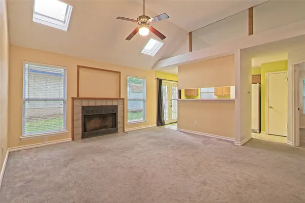 a view of an empty room with a fireplace and a window