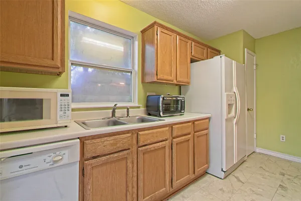 a kitchen with a sink a refrigerator and cabinets