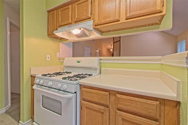 a kitchen with stove and cabinets
