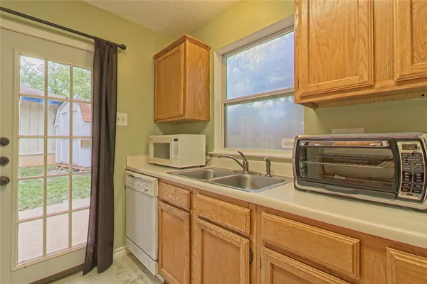 a kitchen with a sink cabinets and a window
