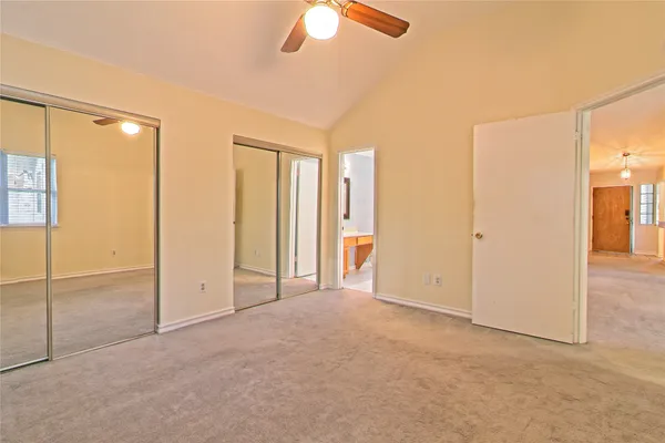 an empty room with closet and a chandelier fan