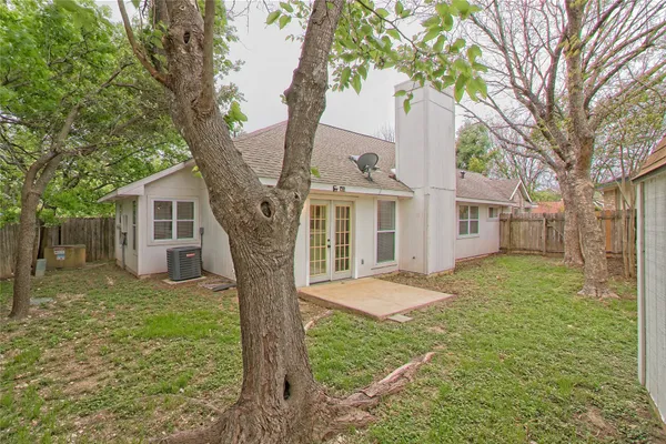 a view of a yard in front of a house with large tree