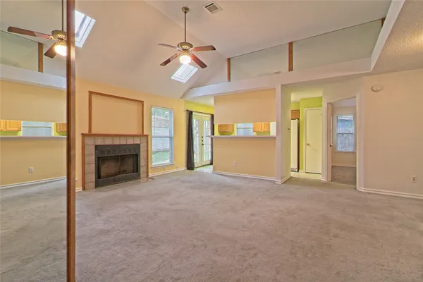 a view of an empty room with a fireplace and a window
