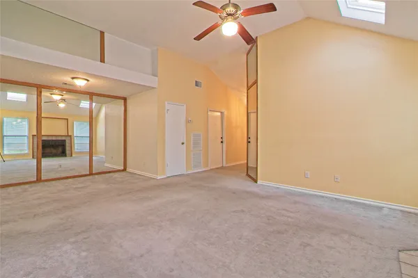 an empty room with a ceiling fan and a window
