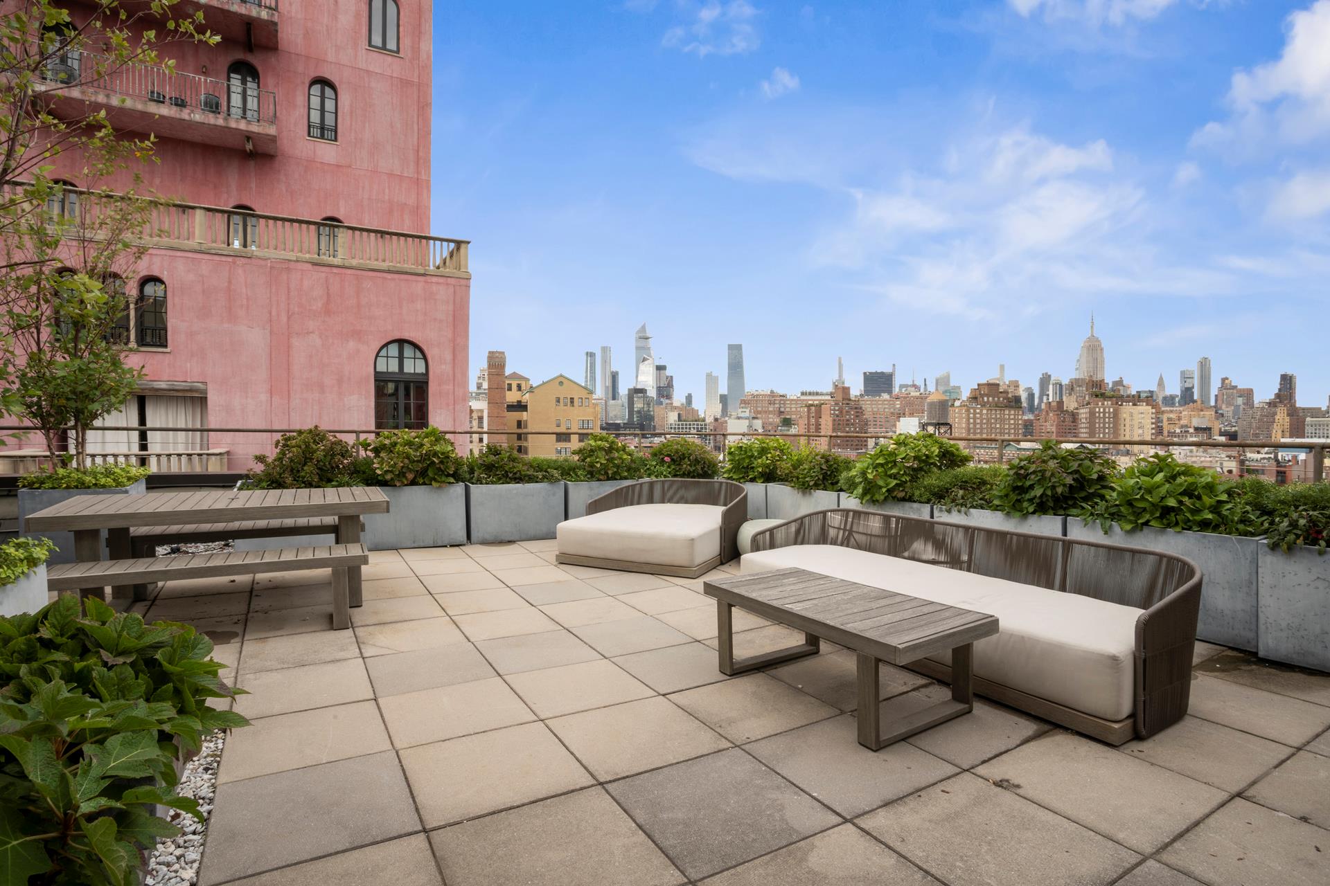 a view of roof deck with couches and potted plants